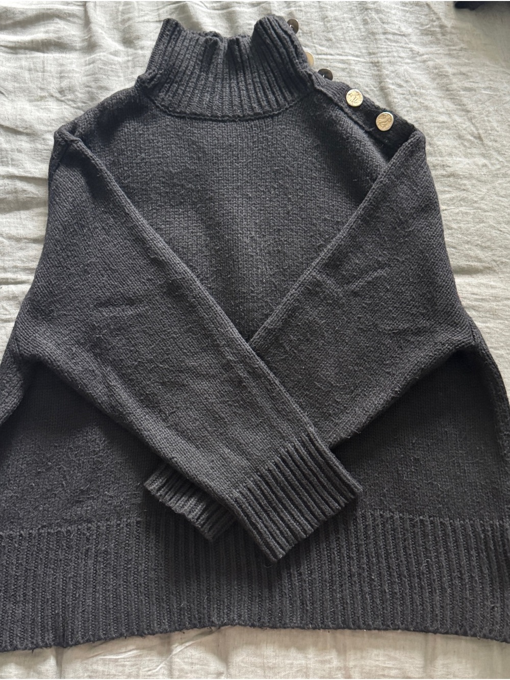 Zara women’s black mock neck sweater with button detail.